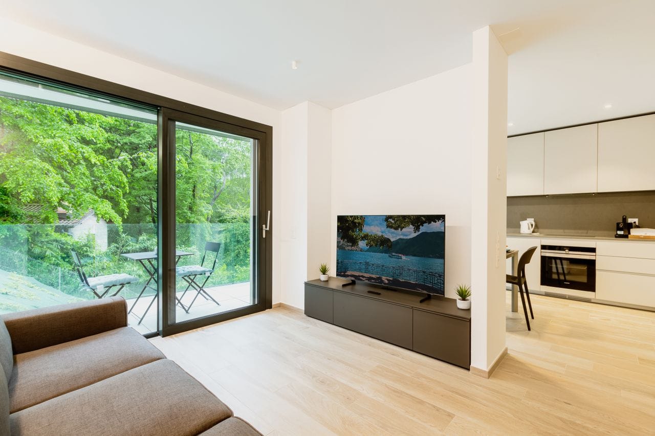 our-story-01 Stylish open-plan apartment featuring minimalist design and greenery view.