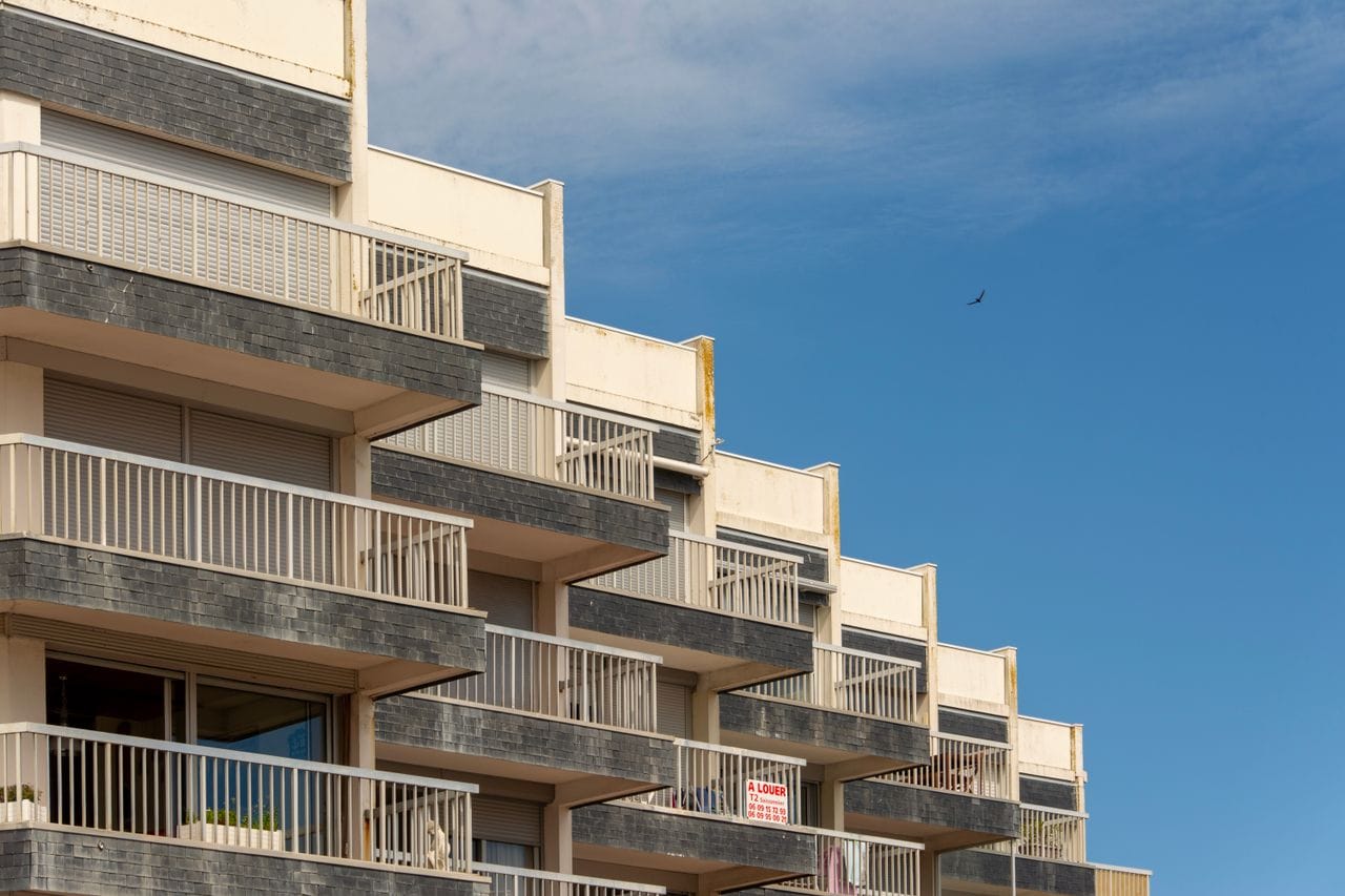 The Art of Drawing Readers In: Your attractive post title goes here A modern apartment building with distinct balconies against a clear blue sky.